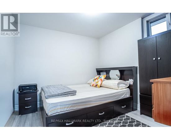 A bedroom with a bed, nightstand, and wardrobe.