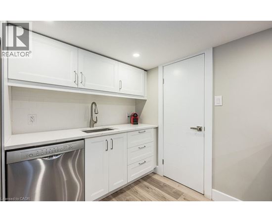 A kitchen with white cabinets and a stainless steel dishwasher.