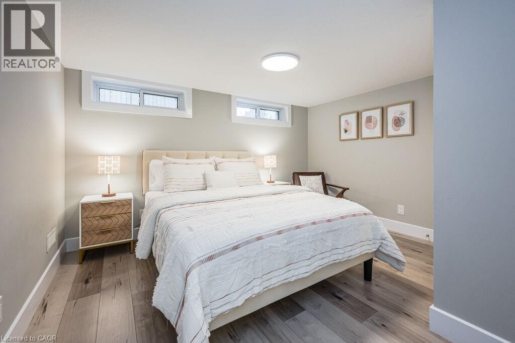 A bedroom with a large bed and a wooden nightstand.