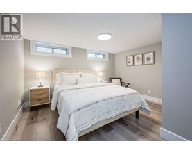 A bedroom with a large bed and a wooden nightstand.