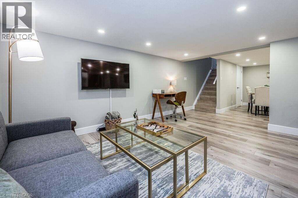 A living room with a grey couch and a glass coffee table.