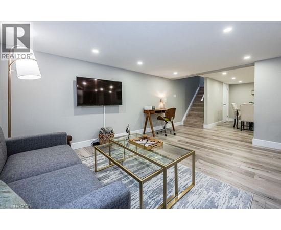 A living room with a grey couch and a glass coffee table.