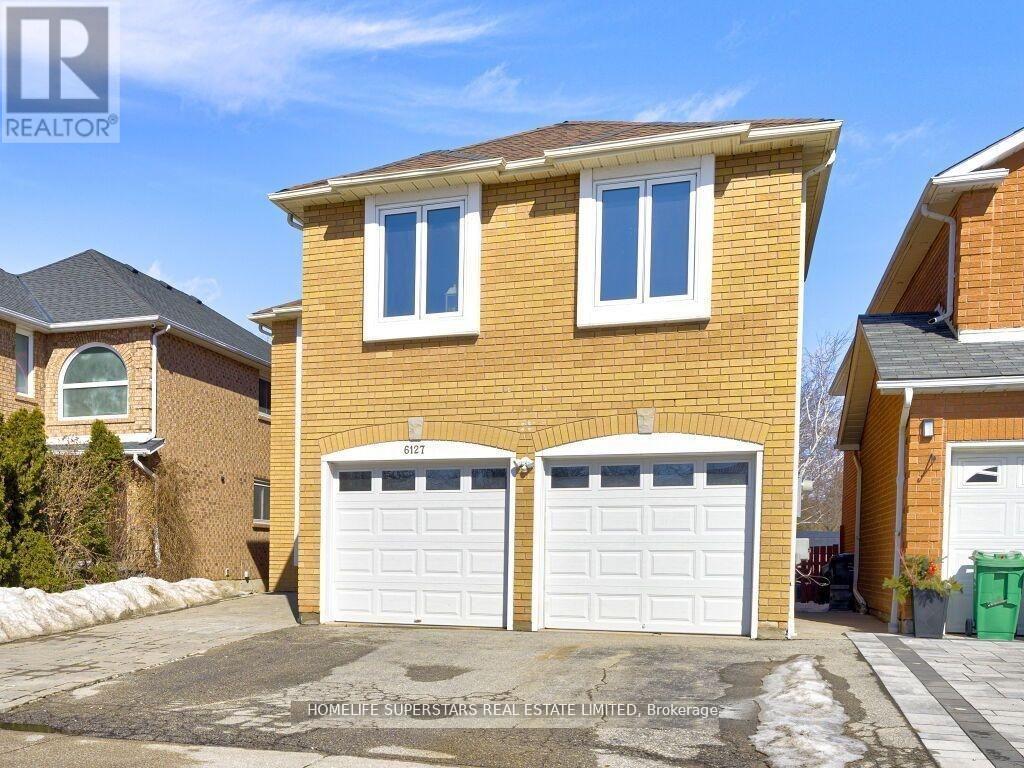 A two-story brick house with a garage is for sale.