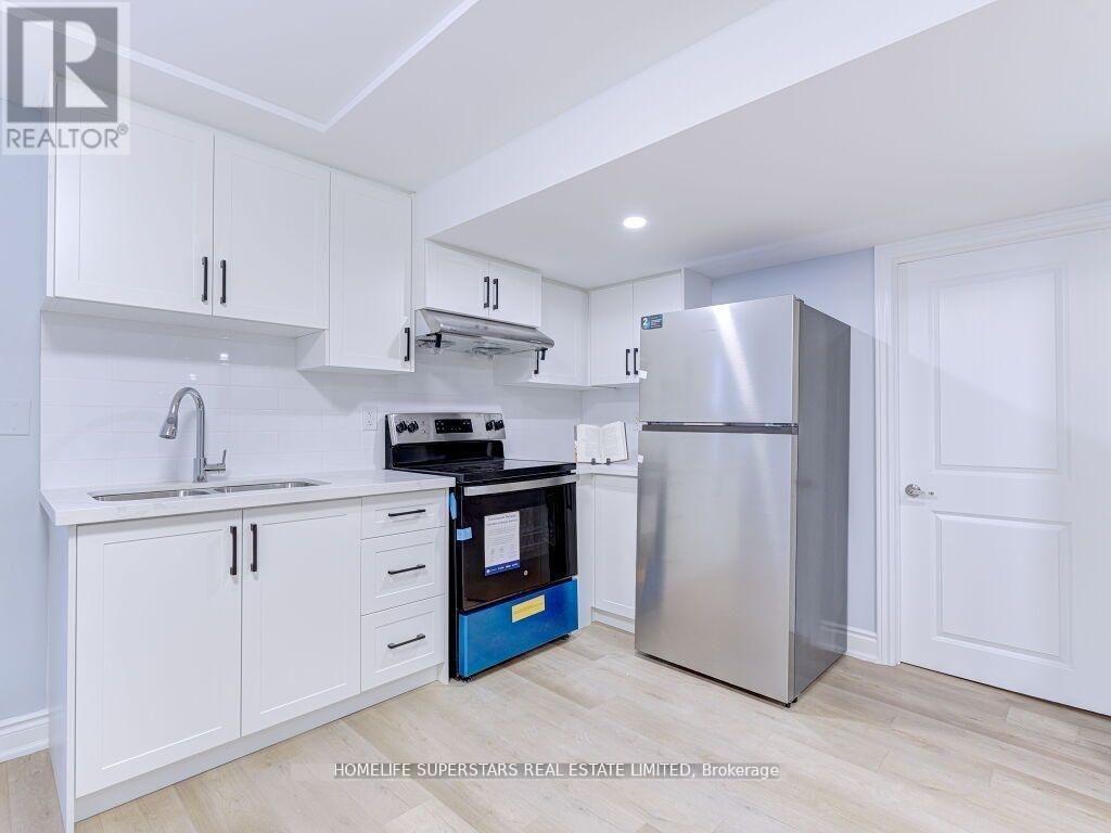A kitchen with white cabinets and a stainless steel refrigerator.