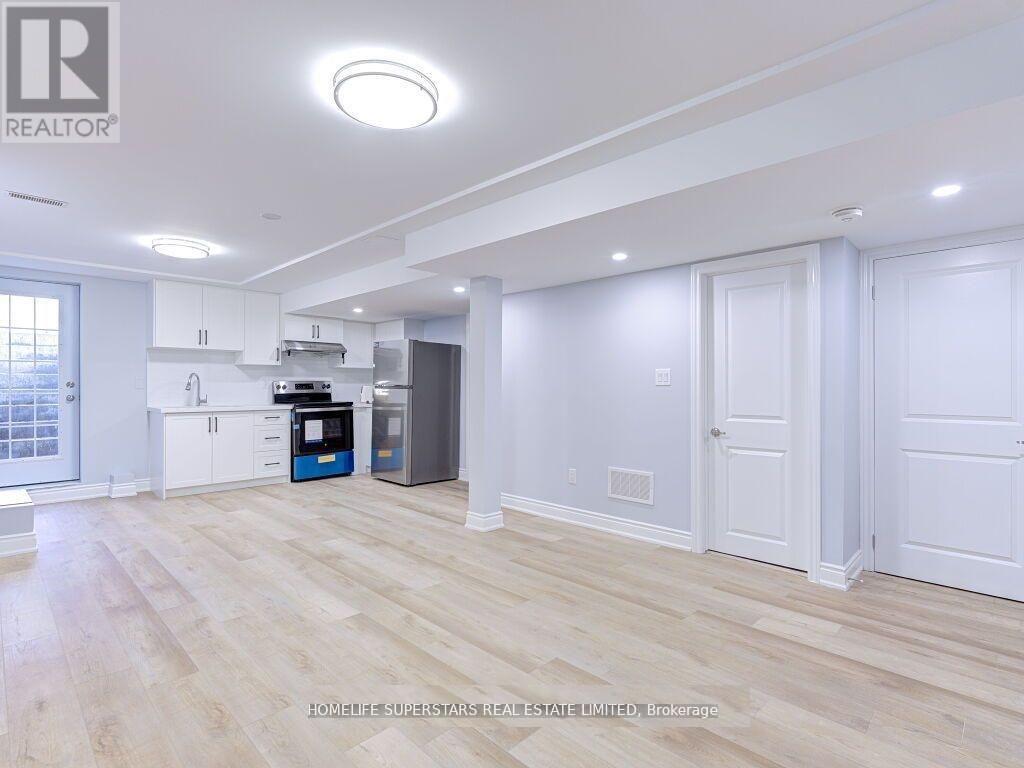 A spacious kitchen with white cabinets and a blue island.