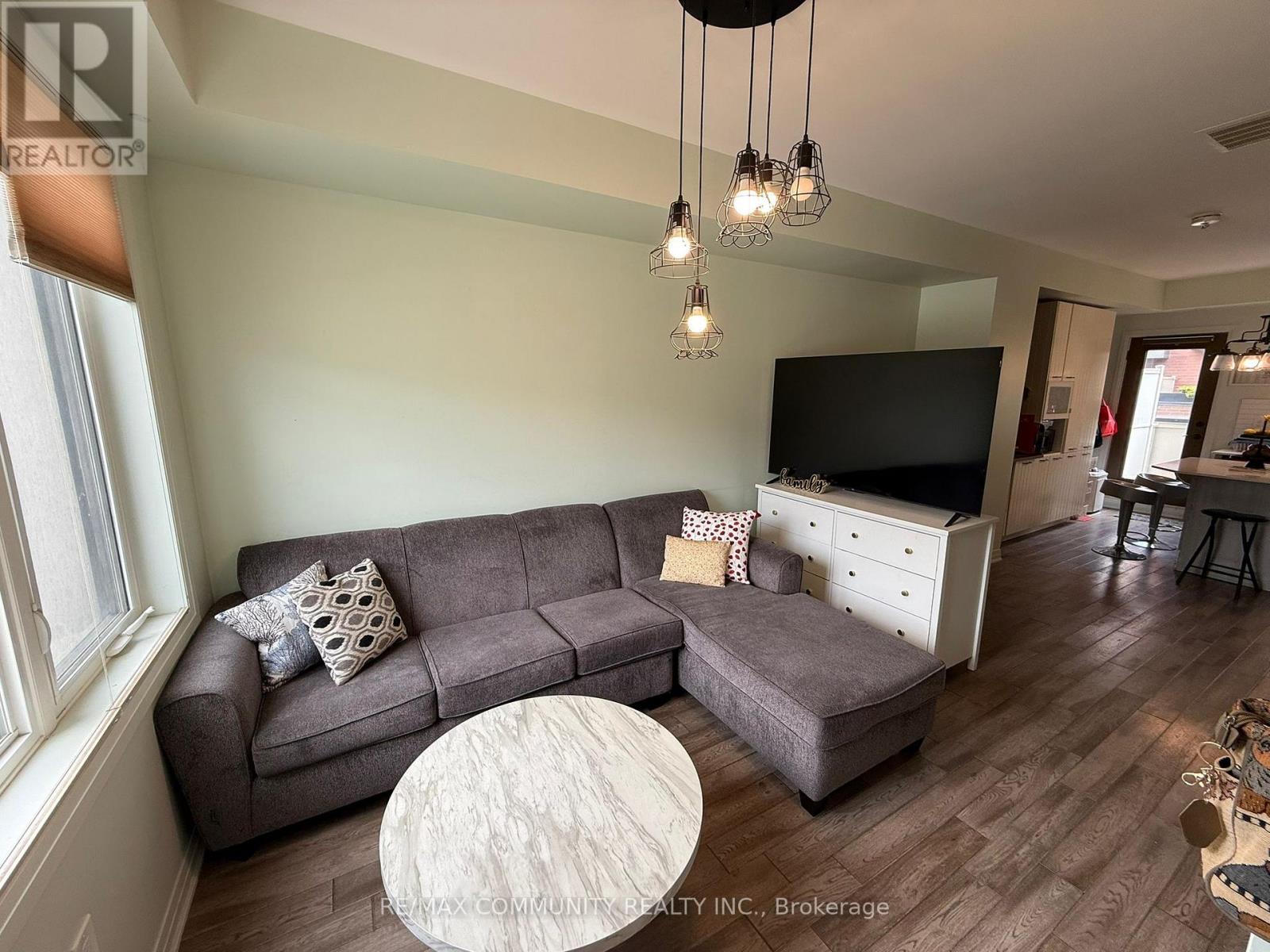 A living room with a grey couch and a white coffee table.