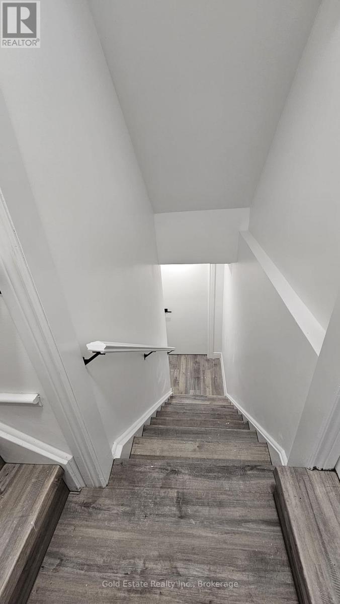 A hallway with a wooden floor and white walls.