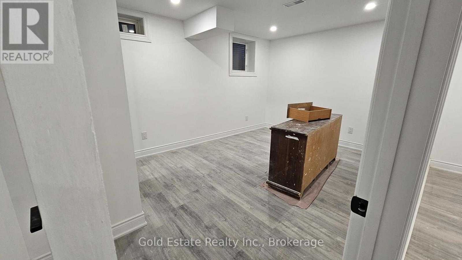 A room with a wooden box on a pedestal in the middle of the room.