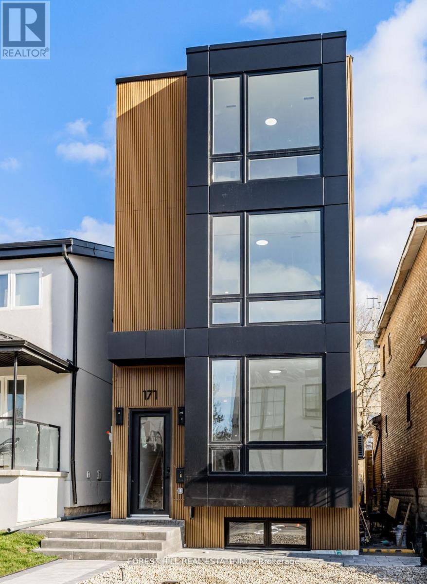 A modern black and wood building with a glass door and windows.