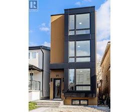 A modern black and wood building with a glass door and windows.