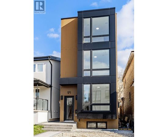 A modern black and wood building with a glass door and windows.