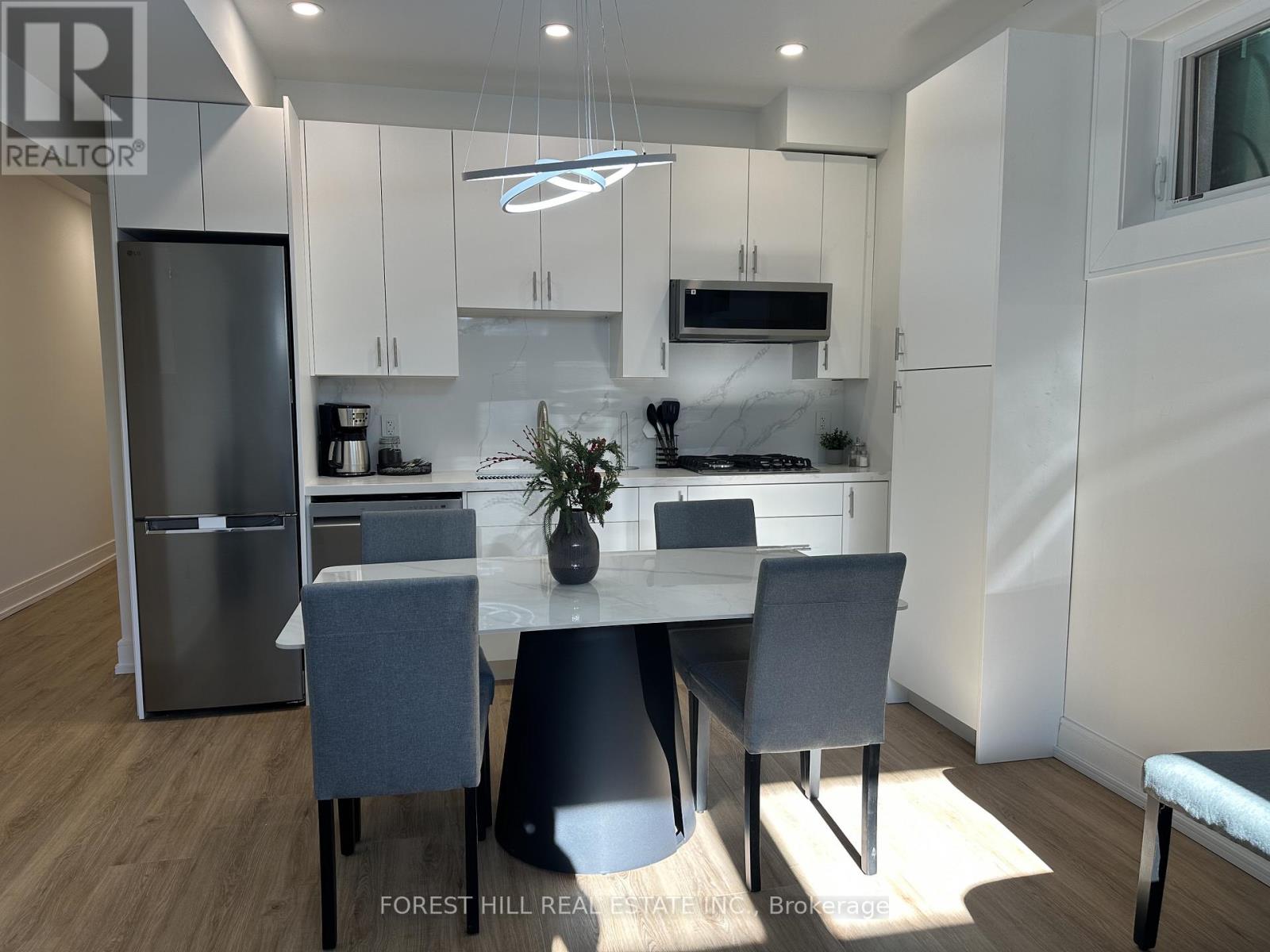 A modern kitchen with a dining table and chairs.