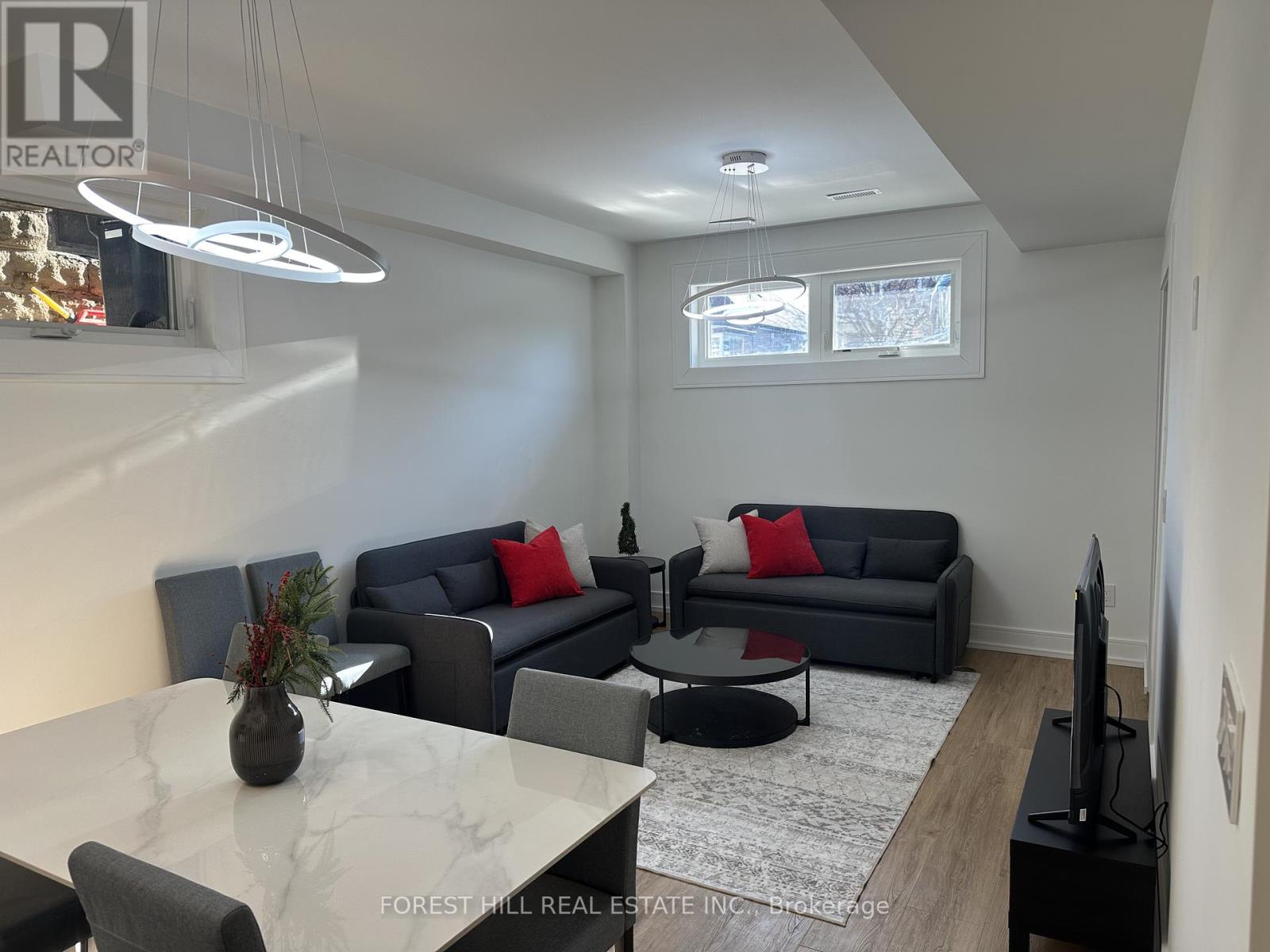 A living room with a grey couch and a white marble table.