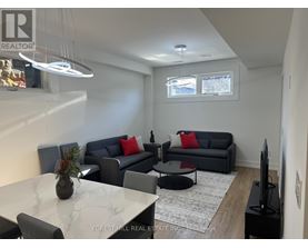A living room with a grey couch and a white marble table.