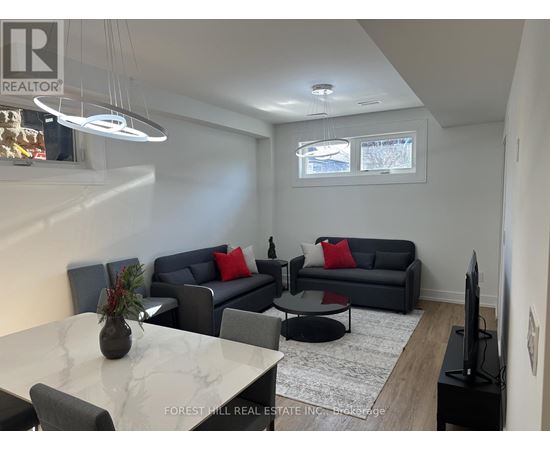 A living room with a grey couch and a white marble table.