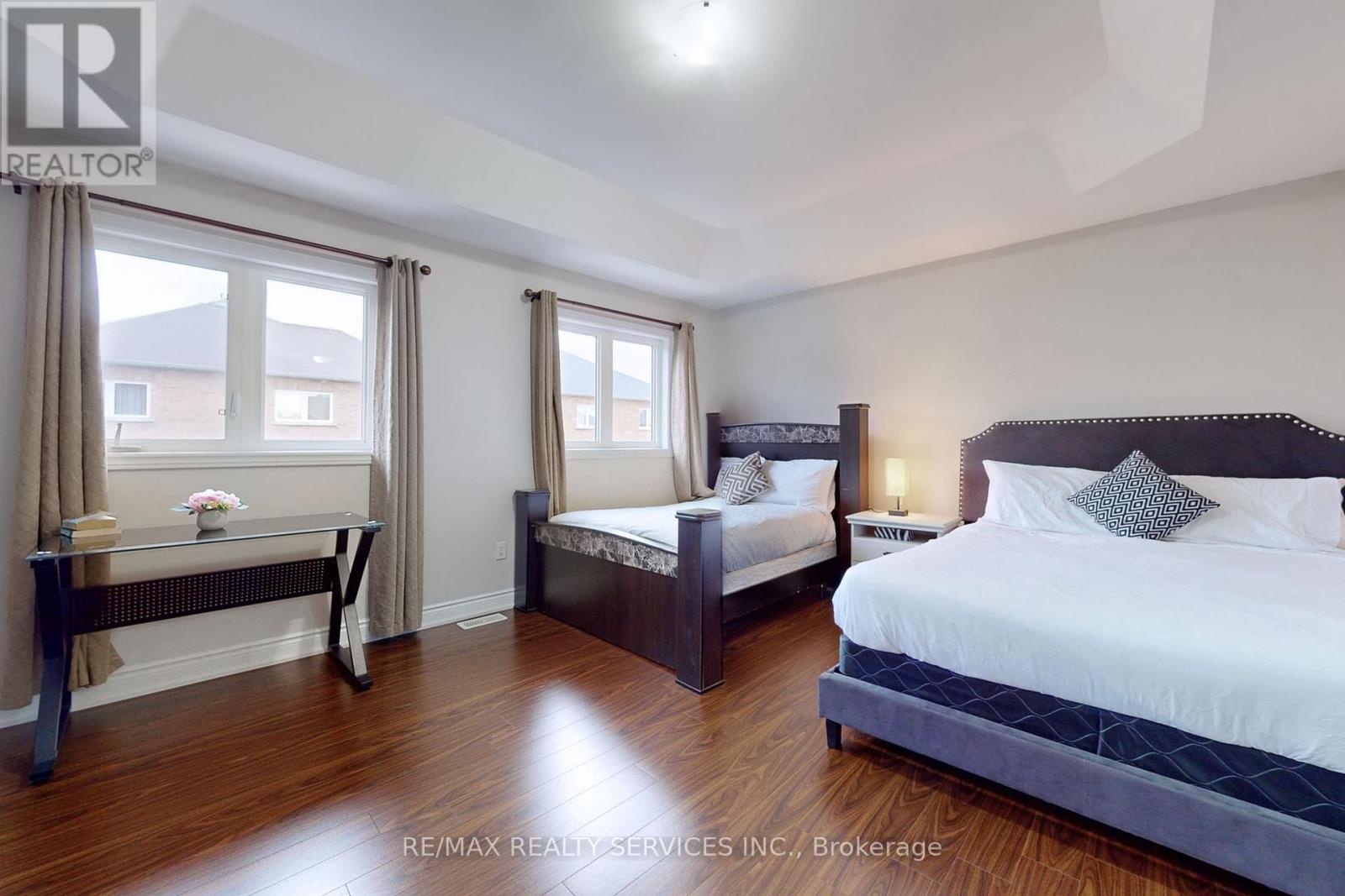 A bedroom with two beds and a bench.