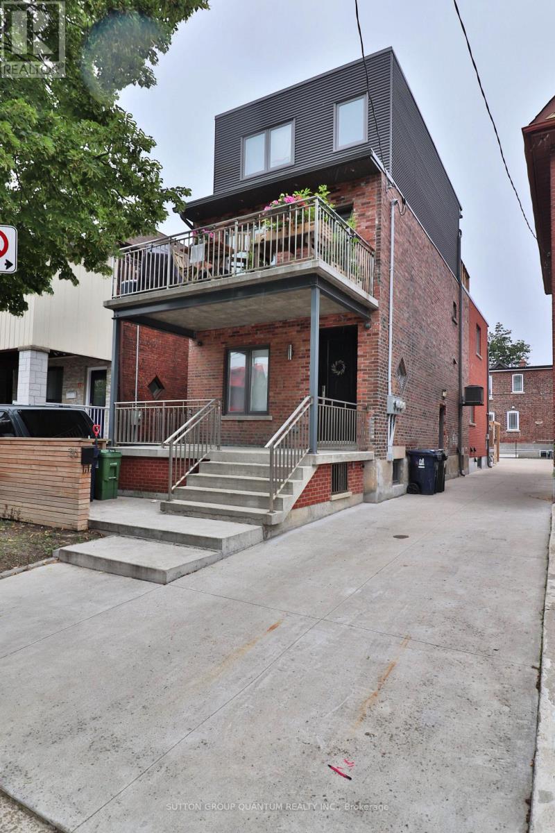 A red brick building with a balcony and a black roof.