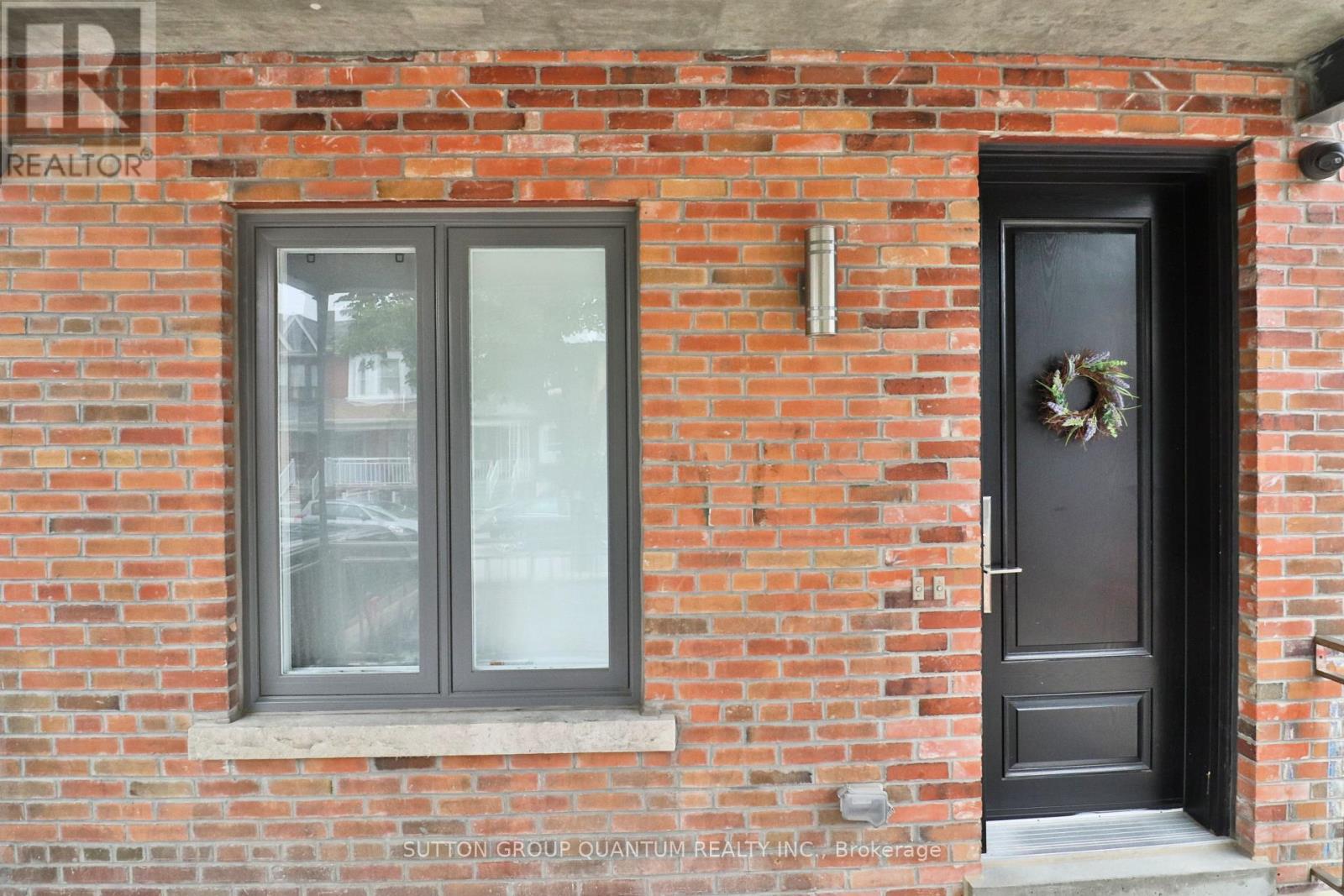 A brick wall with a door and a window.