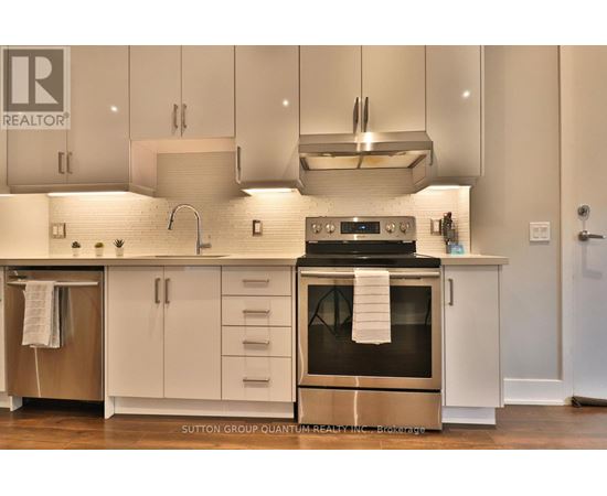 A modern kitchen with white cabinets and a stainless steel oven.