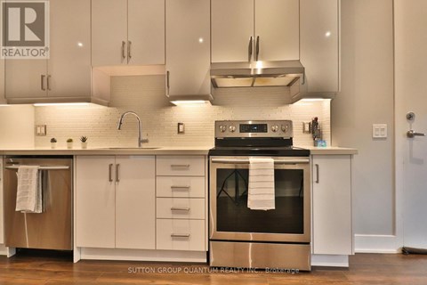 A modern kitchen with white cabinets and a stainless steel oven.