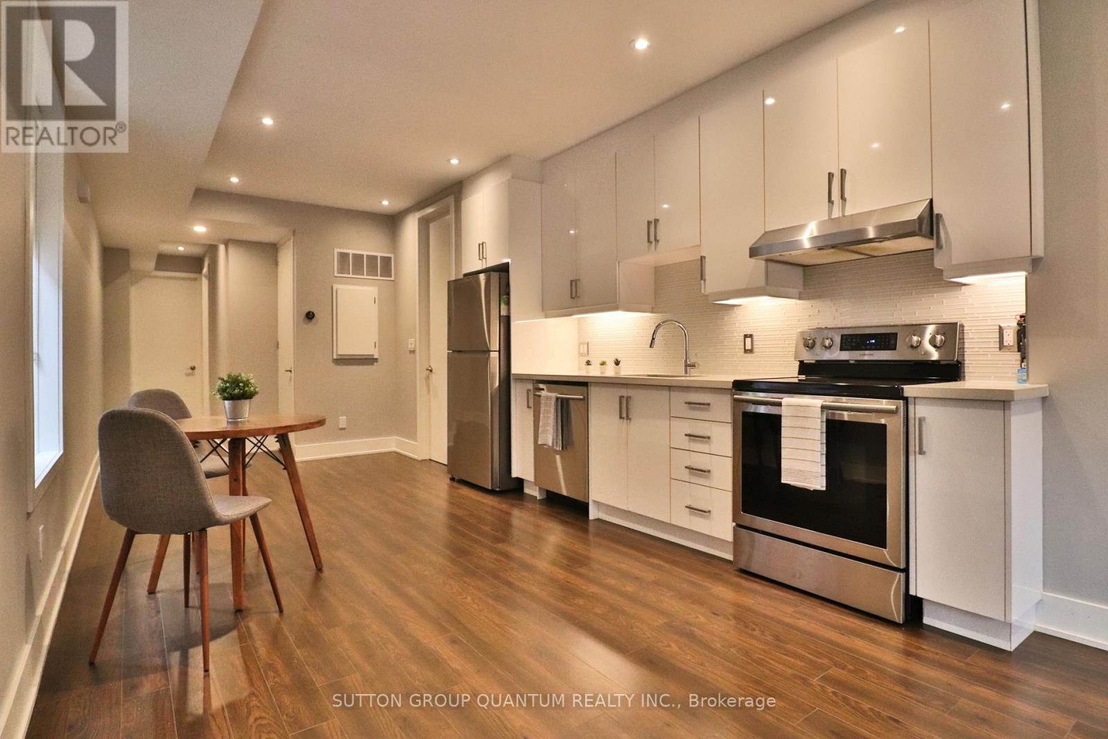 A modern kitchen with white cabinets and stainless steel appliances.