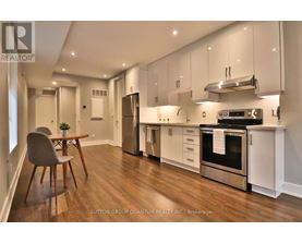 A modern kitchen with white cabinets and stainless steel appliances.