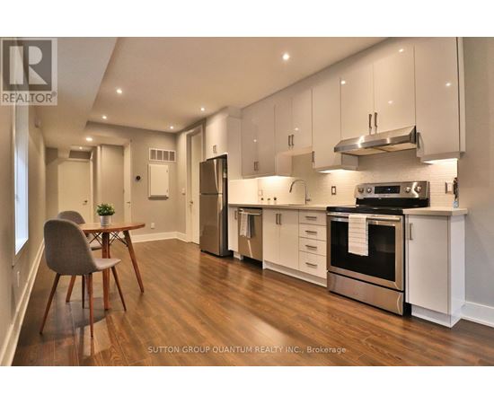 A modern kitchen with white cabinets and stainless steel appliances.