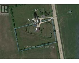 An aerial view of a property with a road and a building.