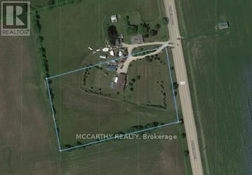 An aerial view of a property with a road and a building.