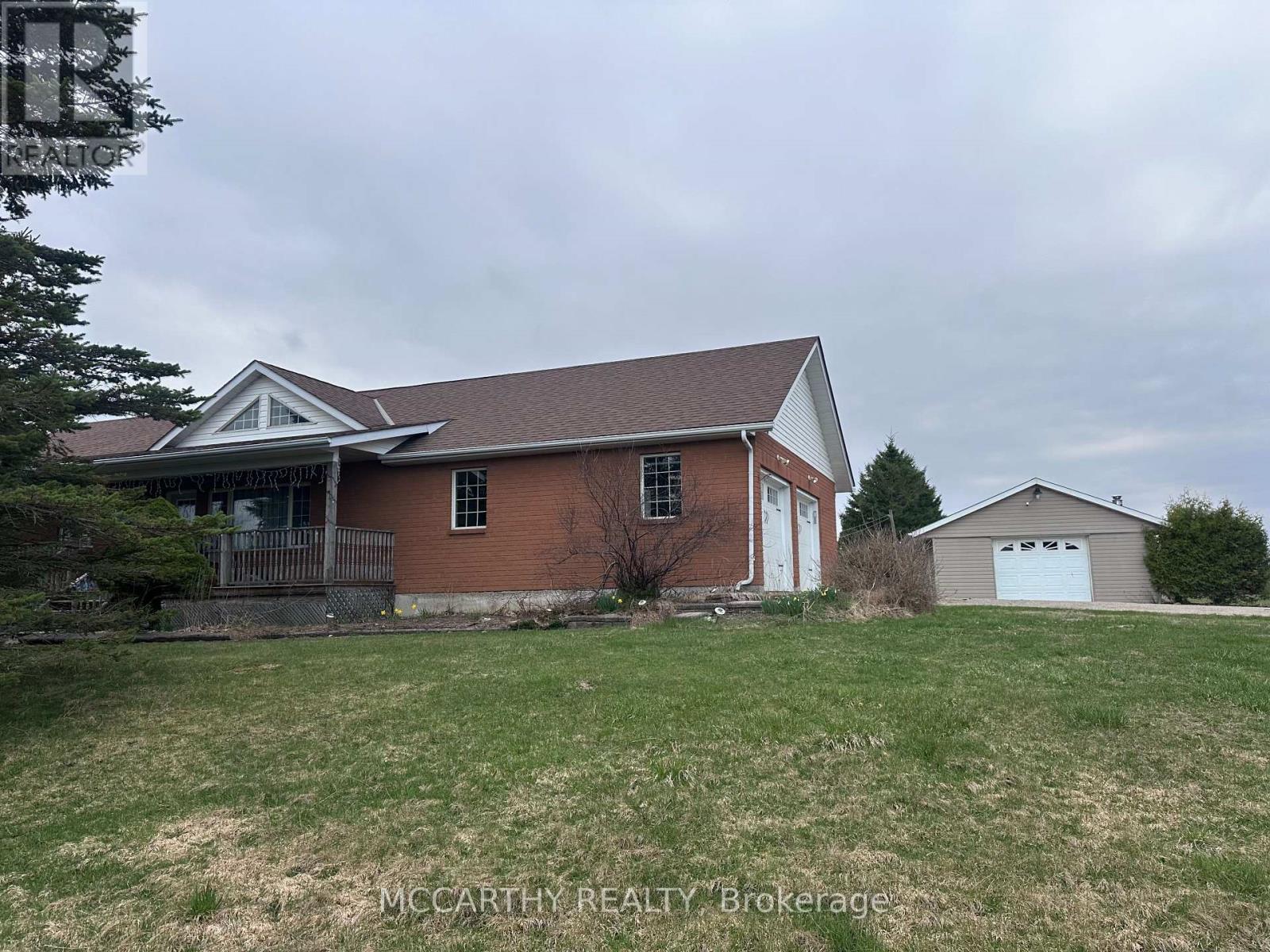 A house with a brown brick exterior and a white garage door.