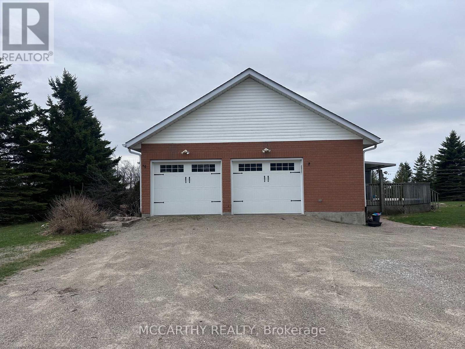 A two-car garage with a brick exterior and a white roof.