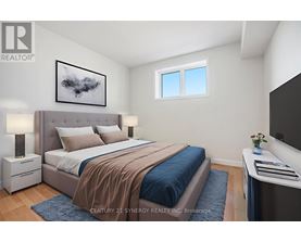 A bedroom with a large bed and a painting on the wall.