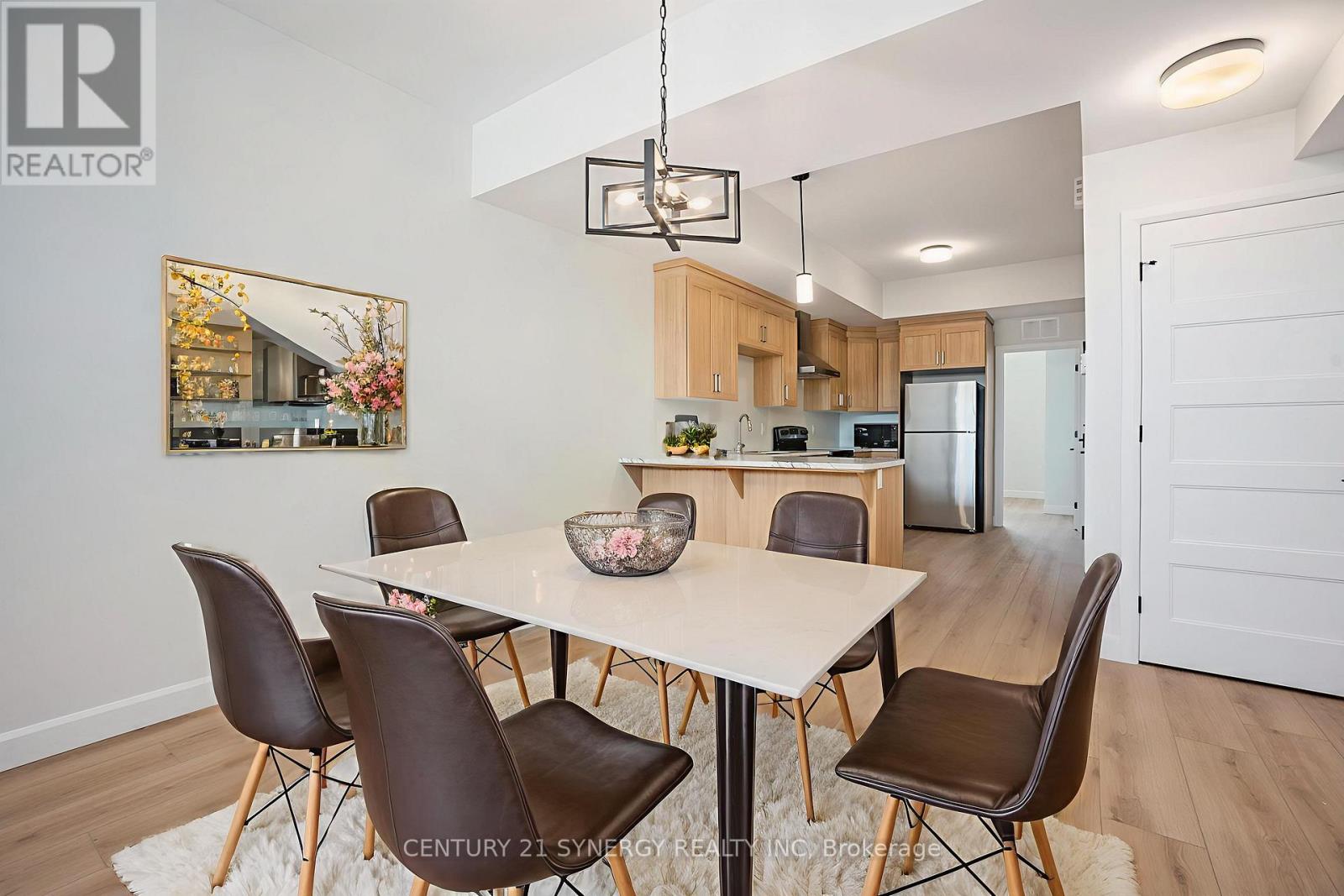 A modern dining room with a white table and brown chairs.
