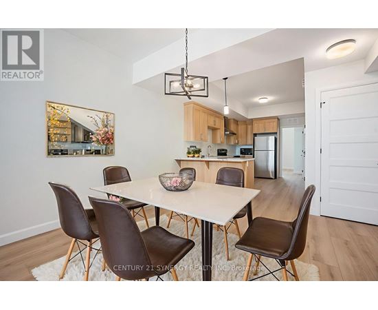 A modern dining room with a white table and brown chairs.