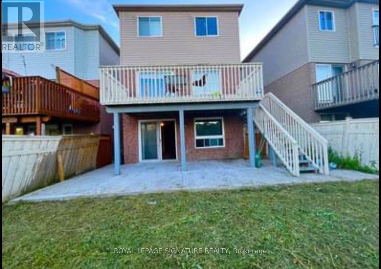 A real estate photo of a home with a balcony and a deck.