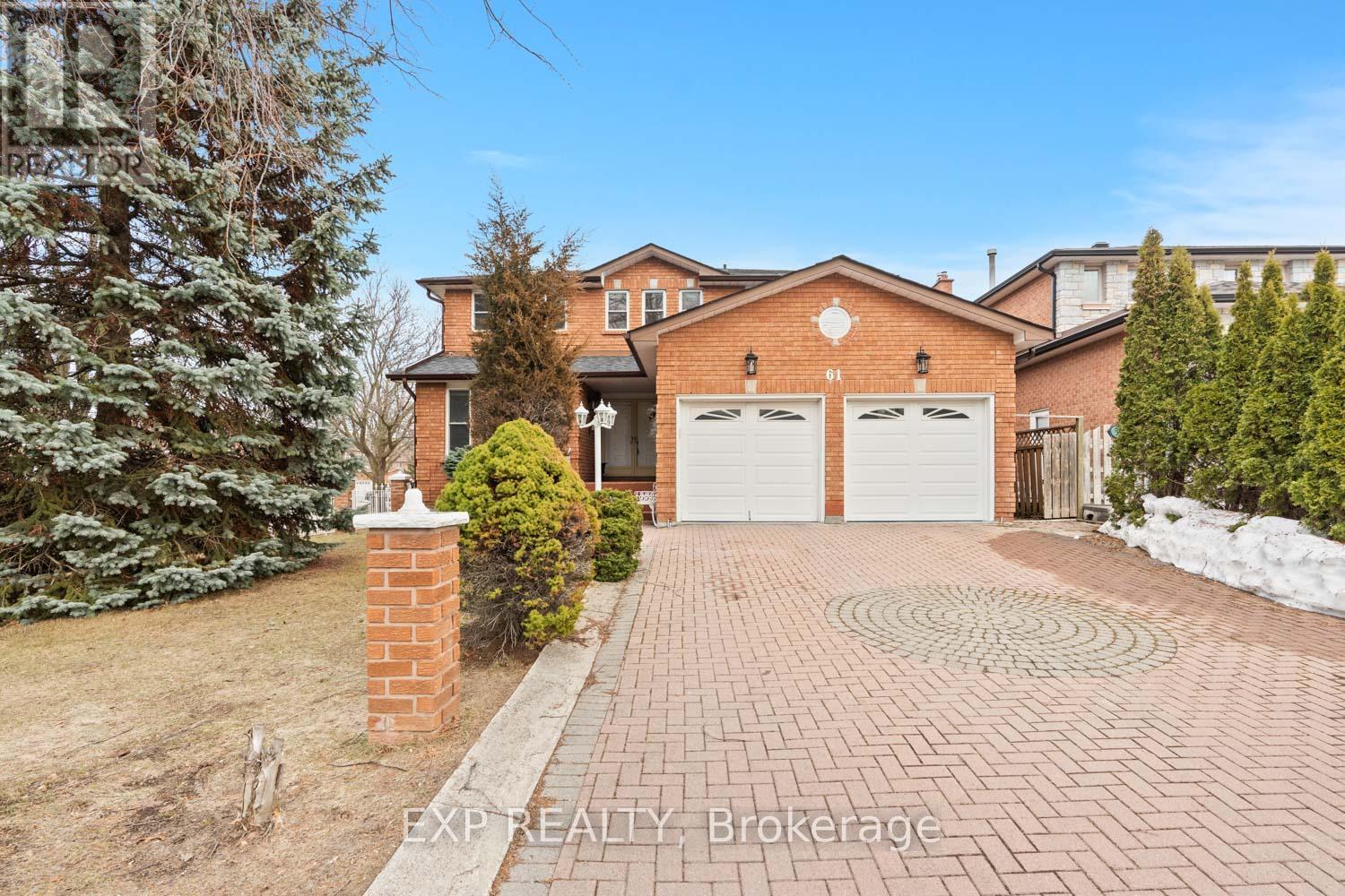 A house with a brick driveway and a snow-covered ground.