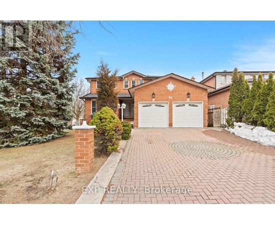 A house with a brick driveway and a snow-covered ground.