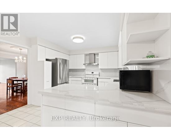 A modern kitchen with white cabinets and a marble countertop.