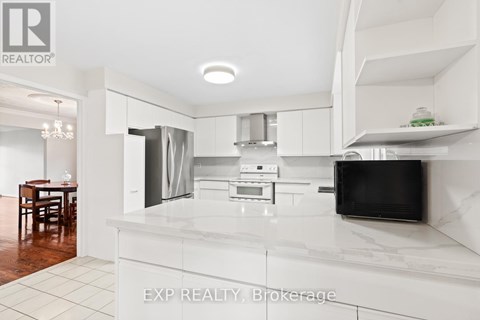 A modern kitchen with white cabinets and a marble countertop.