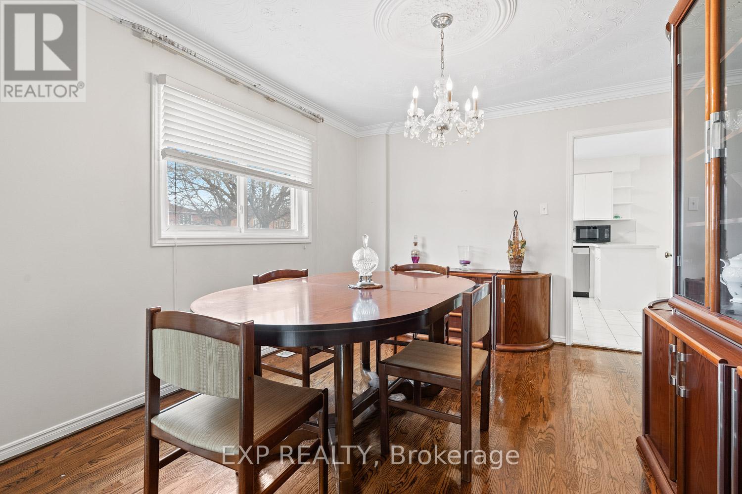 A dining room with a wooden table and chairs.