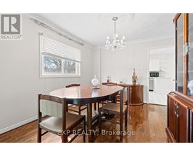 A dining room with a wooden table and chairs.
