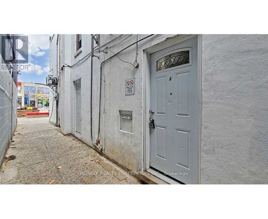 A narrow alley with a white door and a no parking sign.