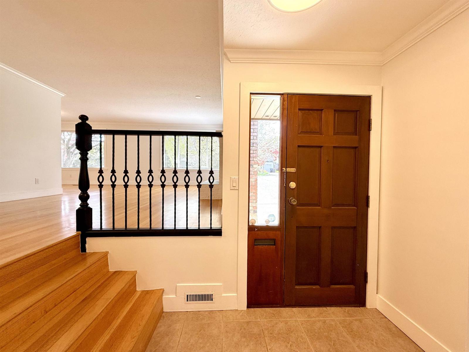 A brown door is at the end of a hallway.