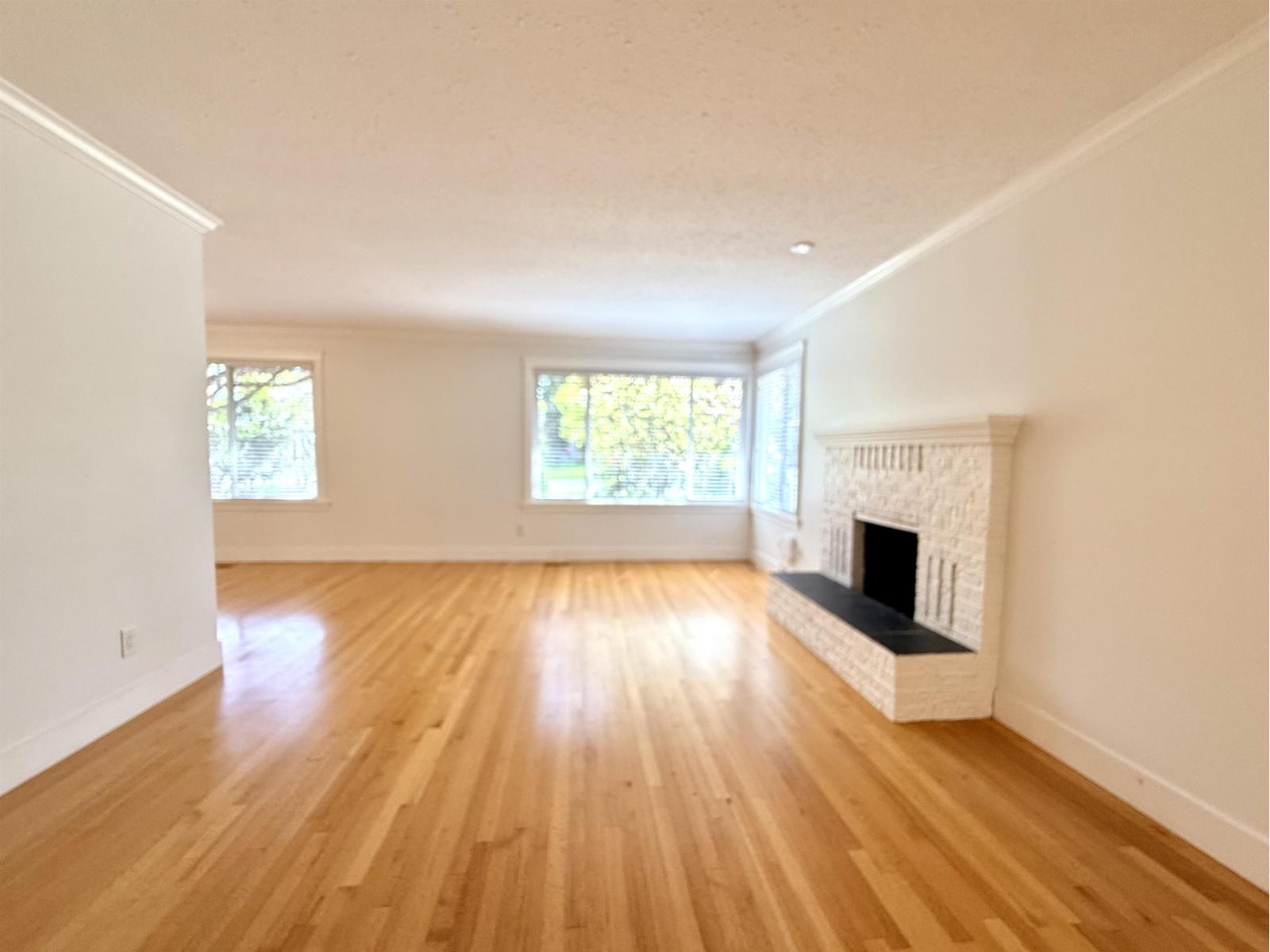 A room with a fireplace and wooden floors.