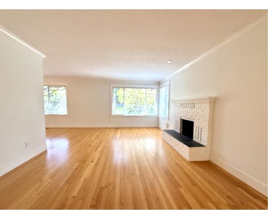 A room with a fireplace and wooden floors.