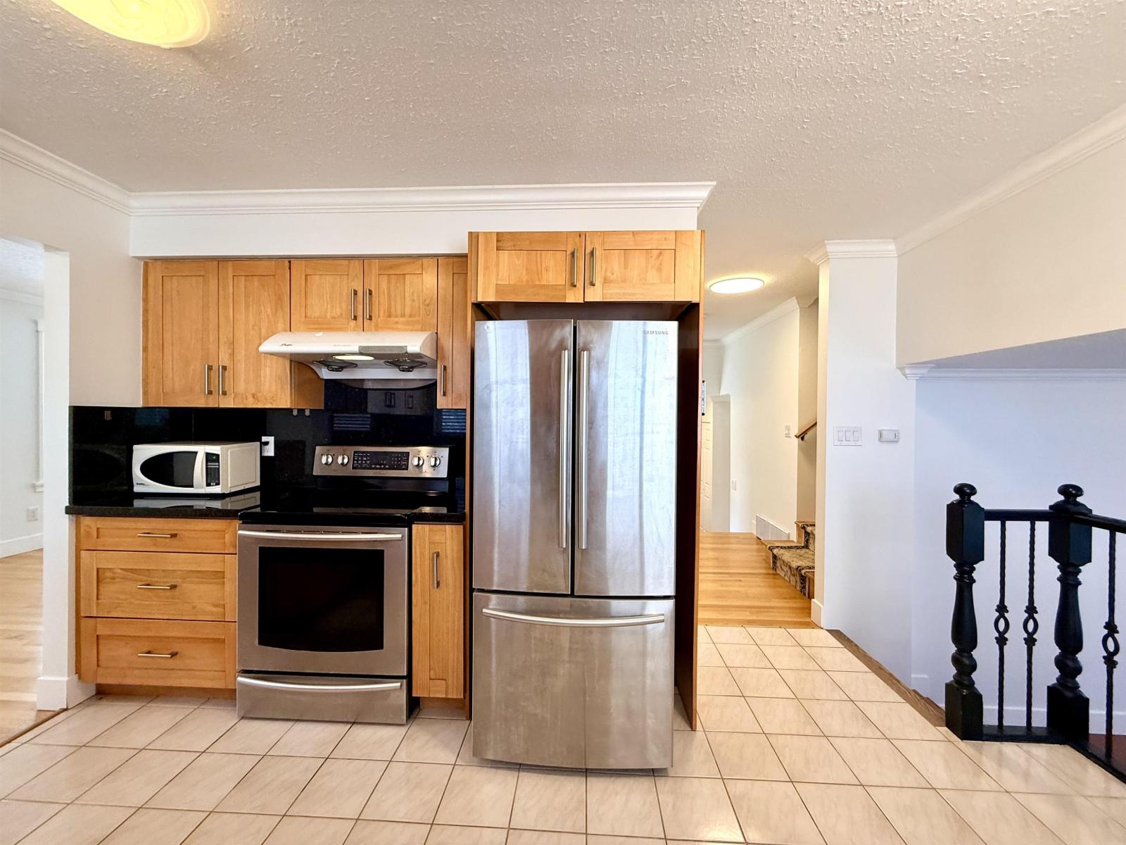 A kitchen with wooden cabinets and a black countertop.