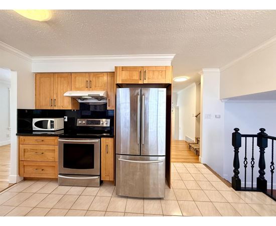 A kitchen with wooden cabinets and a black countertop.