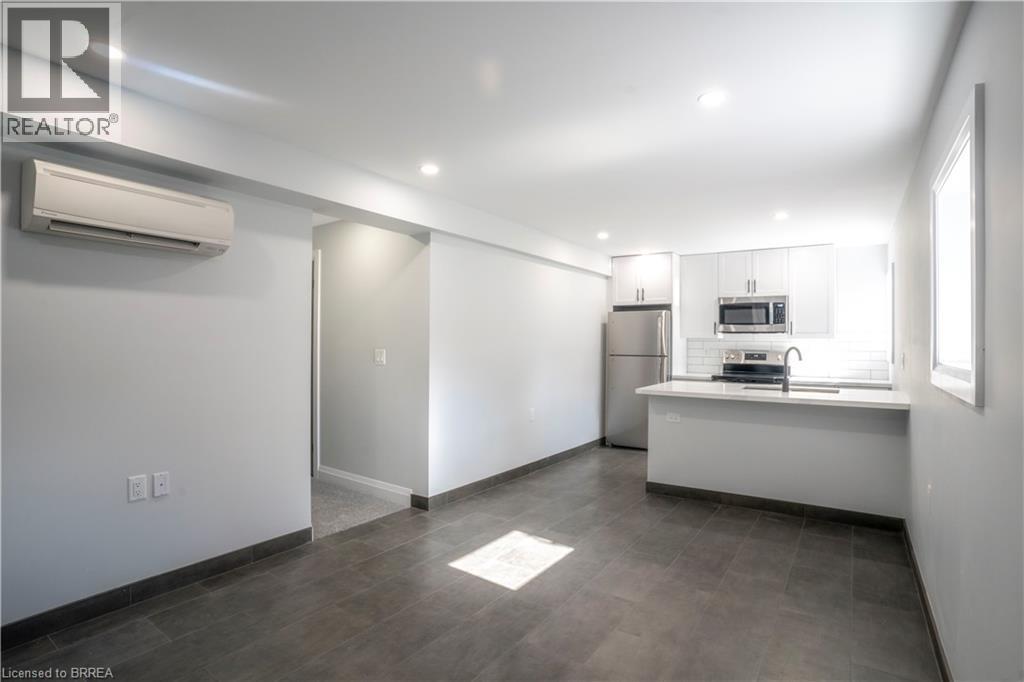 A spacious kitchen with a refrigerator, microwave, and sink.