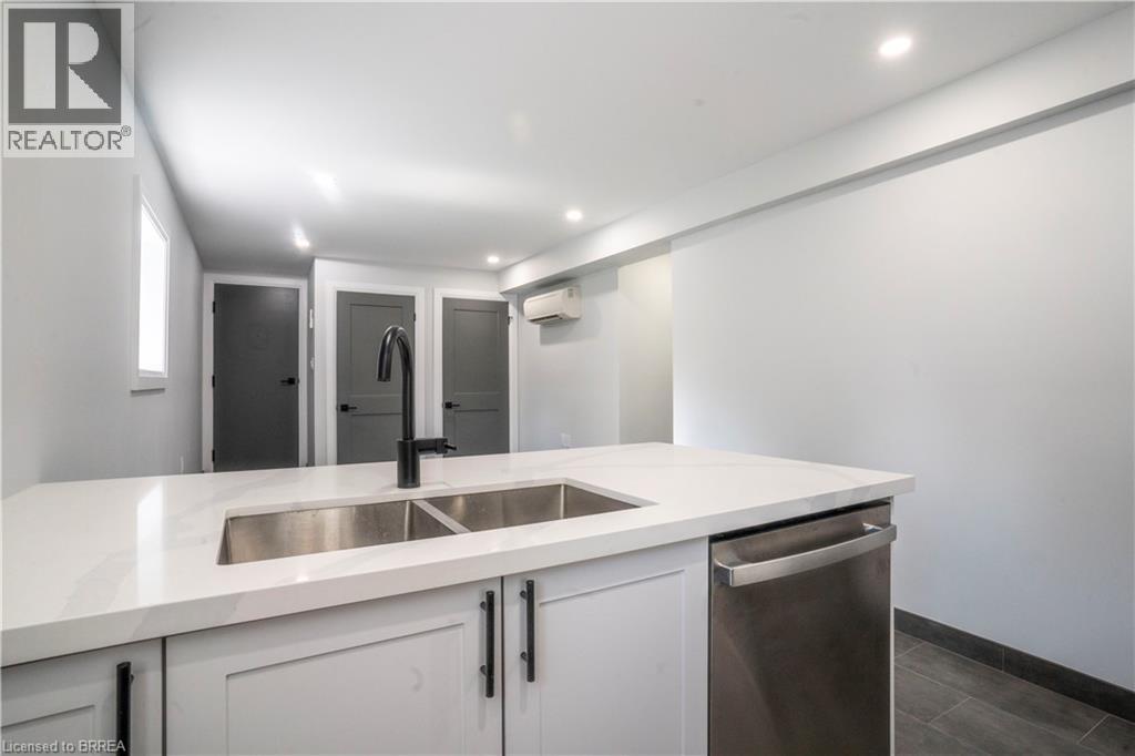 A modern kitchen with white countertops and stainless steel appliances.