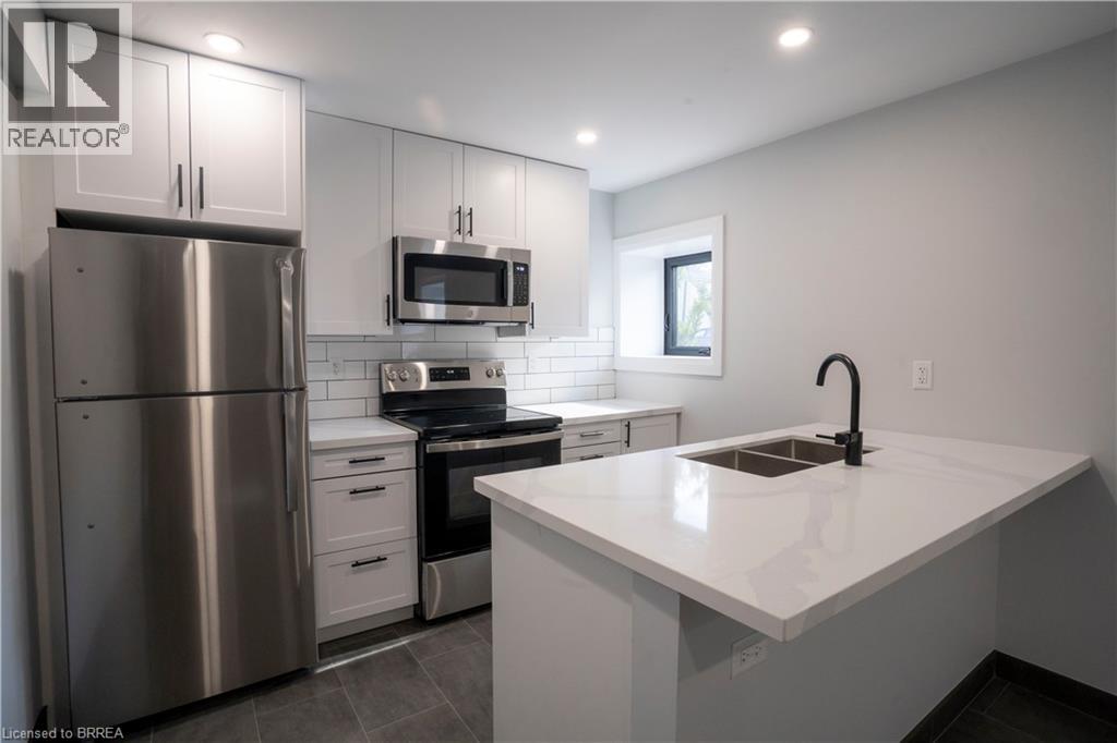A modern kitchen with a stainless steel refrigerator and a white countertop.
